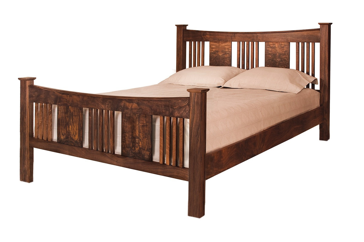 A traditional bed with slats and panels made with dark Walnut wood frame and headboard, dressed in white bedding and two white pillows, shown against a plain white background.