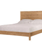 A light oak wood bed frame with a tall rectangular headboard and matching footboard, shown with white bedding and two white pillows on a solid white background.