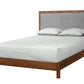A modern wooden bed frame with a gray upholstered headboard, shown with white bedding and two pillows on a plain white background.