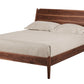 A mid-century modern Walnut wooden bed frame, styled with a cream-colored mattress and two matching pillows, shown against a solid white background.