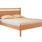 A light Cherry wood bed frame with a slatted headboard and footboard, shown with a mattress and two pillows on a solid white background.
