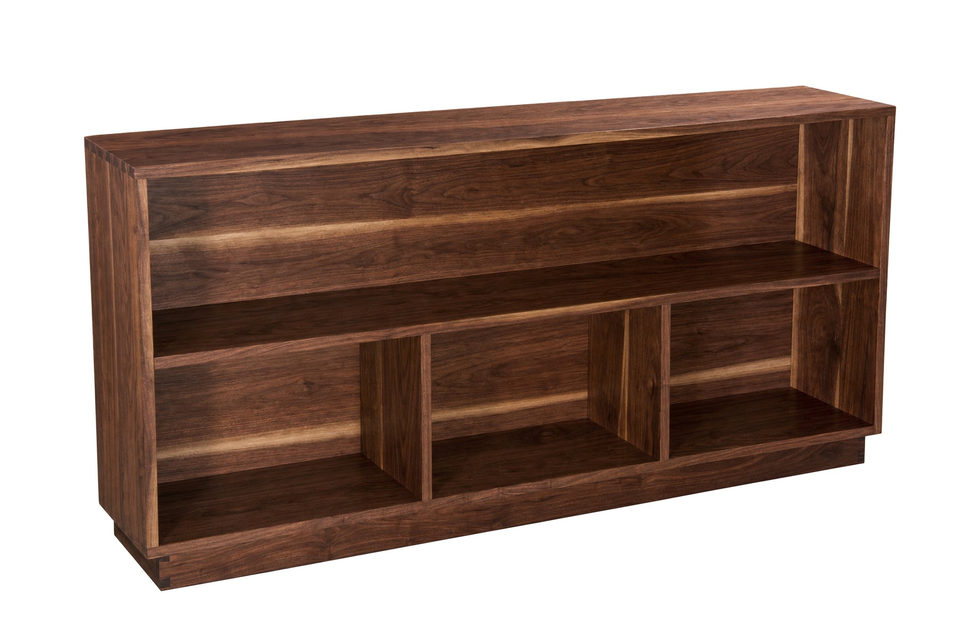 A dark brown wooden bookcase with three open shelves and a slanted top, shown from a three-quarter angle on a white background.