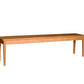 A long rectangular wooden bench with four legs, shown from a side angle on a plain white background.