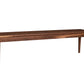 A long rectangular wooden bench with four legs, shown from a side angle on a plain white background.