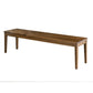 A long rectangular wooden bench with four legs, shown from a three-quarters angle on a plain white background.