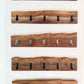 Set of wooden wall coat racks with black and nickel hooks on a white background