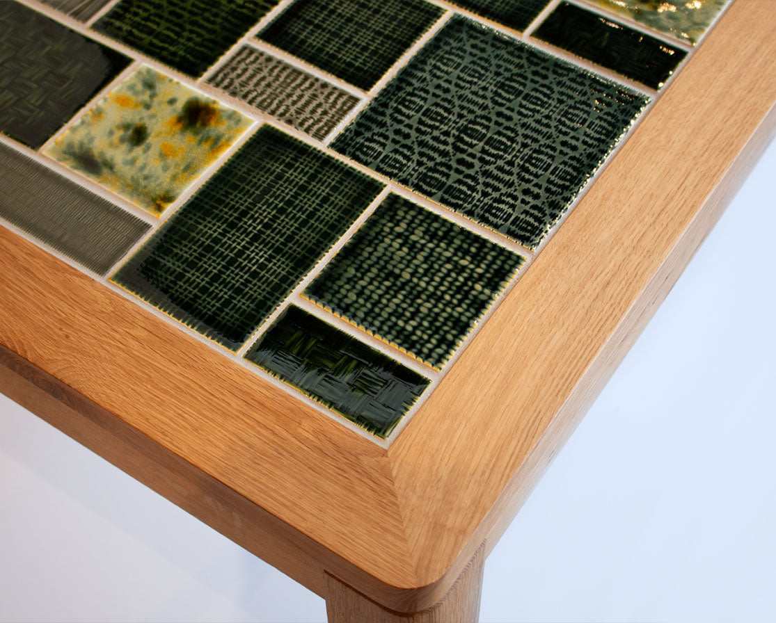 Tabletop with ceramic tiles featuring various patterns and colors on a wooden frame.