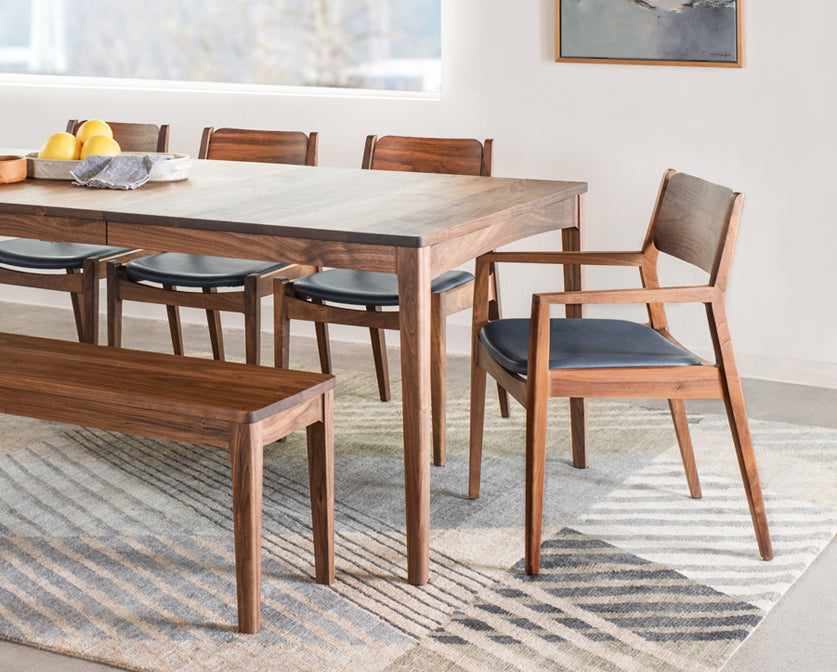 Dining room with wooden table and chairs on a striped rug