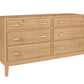 A contemporary wooden dresser with an Oak finish and brass pulls, shown from a three-quarter angle on a white background.