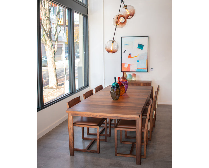 Dining area with wooden table and chairs near a large window.