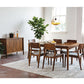 Dining room with wooden furniture including a table and chairs, sideboard, and plants.