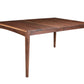 A dark brown wooden extendable dining table with tapered legs, shown from a three-quarter angle on a solid white background.