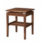 A wooden side table with a warm medium-brown finish, features a lower shelf, and walnut risers under the tabletop, set against a plain white background.