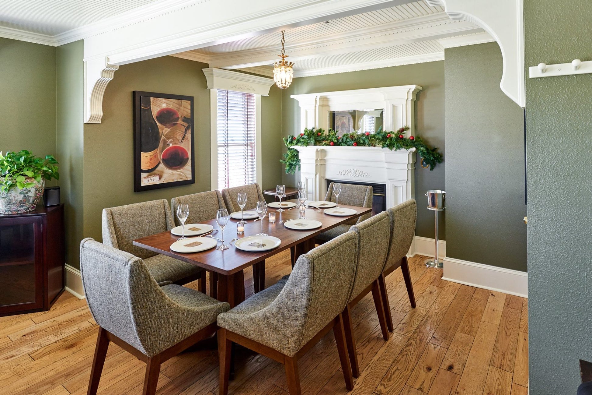 Dining room with wooden table and chairs, fireplace, and artwork on the wall.