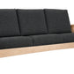A wooden three-seat sofa with dark charcoal gray fabric cushions, shown from a three-quarter angle on a solid white background.