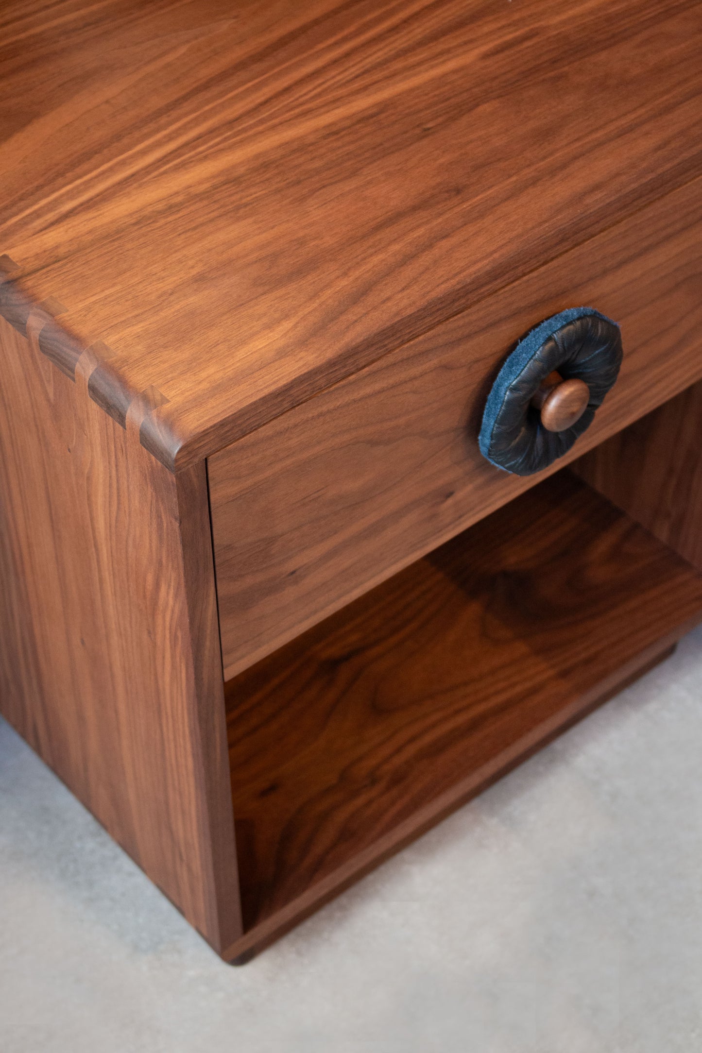 Wooden drawer with a blue handle on a light gray background