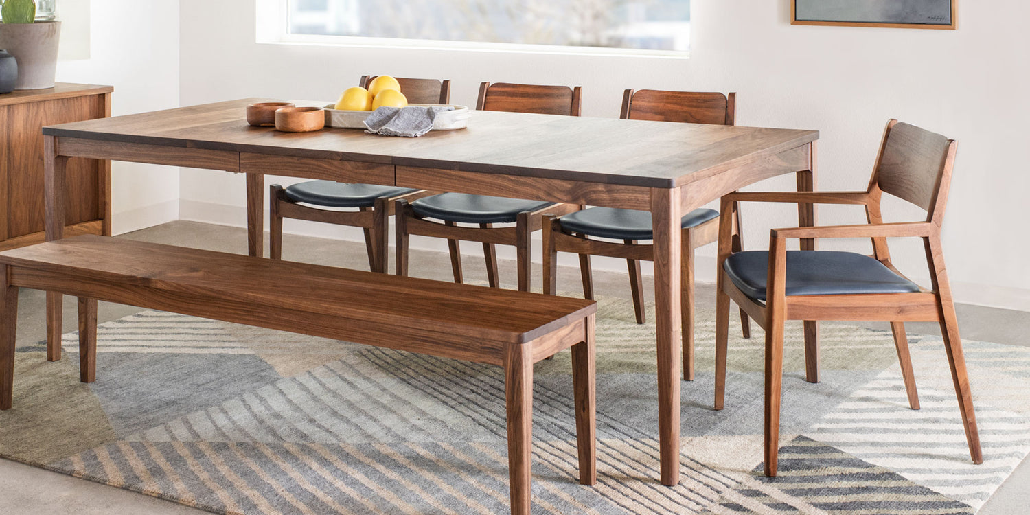 Handcrafted solid wood dining table set in a bright modern interior, showcasing The Joinery’s custom design and finish details.